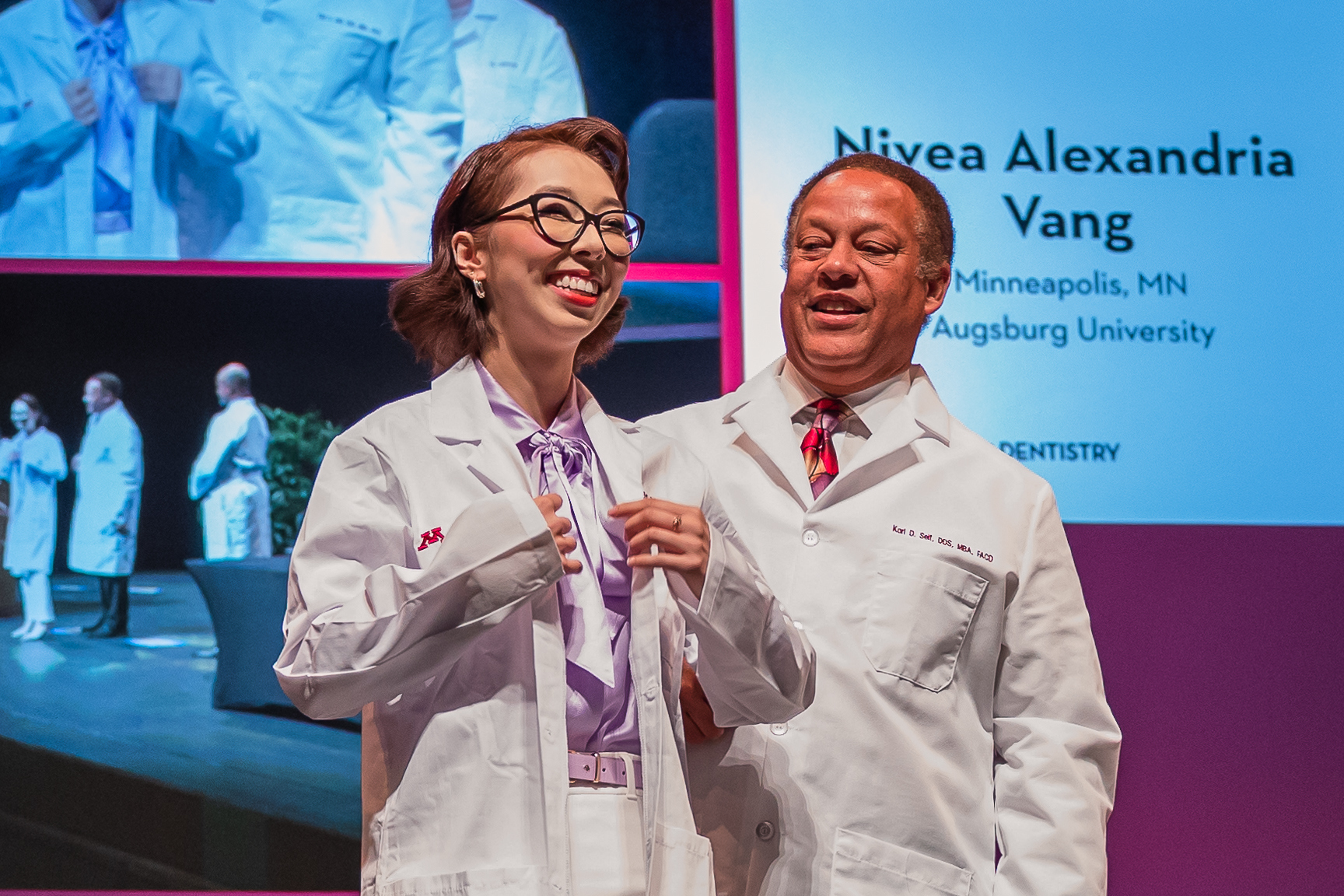 Student receives their white coat on stage