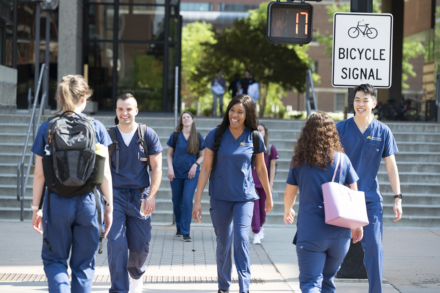 A number of dental students cross the road in front of Moos Tower