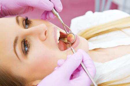 young female patient opens mouth during dental examinations