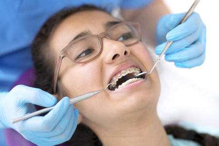 young female patient with glasses and braces is attended to