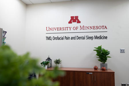 Sign and front desk of the University of Minnesota's TMD, Orofacial Pain and Dental Sleep Medicine Clinic