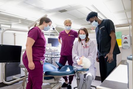 Learners observe as a faculty member demonstrates on a manikin