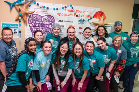 Student and faculty volunteers pose in their Give Kids a Smile t shirts