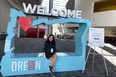 Parandis Kazemi poses with the AADOCR Oregon Welcome sign