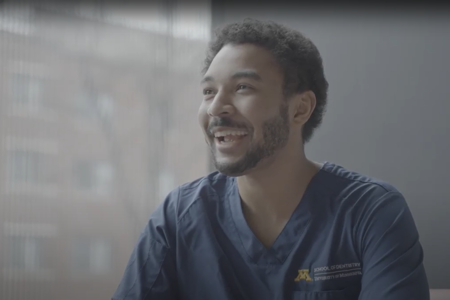 Isaac Tade smiles and looks at someone off camera