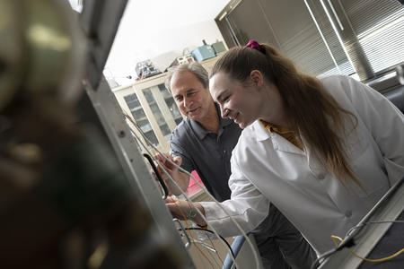 Dr. Simone and a student observe in a lab