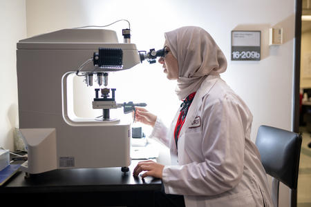 MDRCBB scientist viewing something in a microscope