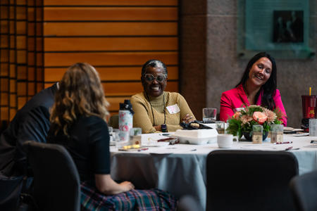 Joy Wise Davis smiles and talks with others at her table