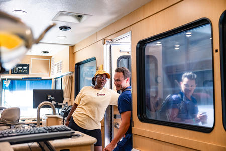 Allysha Comer holds the door open to the Mobile Dental Clinic for a DDS student