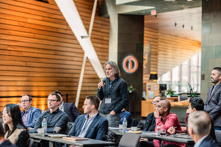 An attendee stands to ask a question