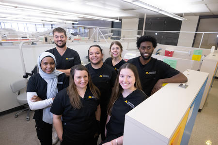 Dental therapy students standing together smiling for picture.