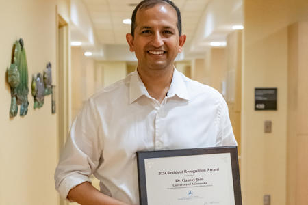 Gaurav Jain holding resident recognition award