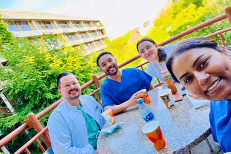Four students take a selfie at an outdoor table in Heidelberg