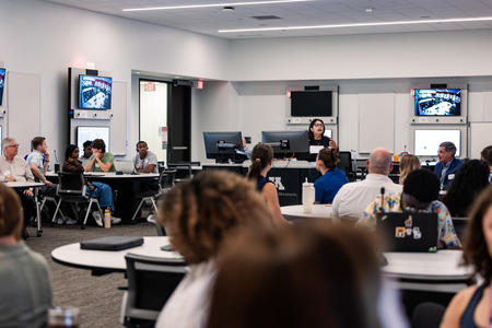 Participants listen to a talk during the summer research exchange