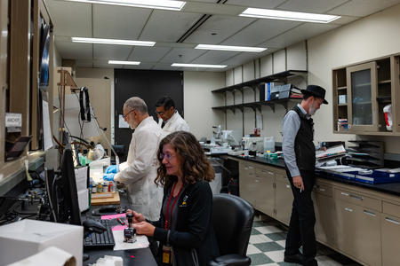 4 individuals working in oral pathology lab.