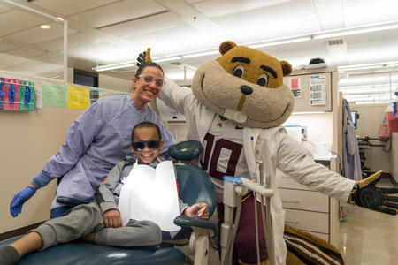 Goldy smiling with young patient.