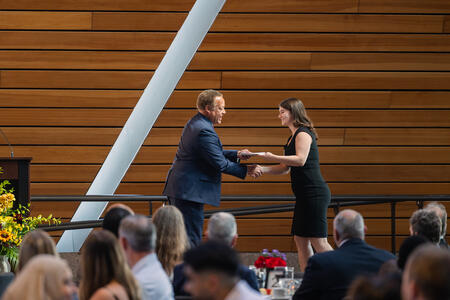 Cecilia Lovinger receives an award from Karl Self onstage