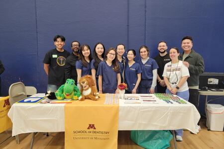 Students and staff pose at the school's booth at the Hmong fair