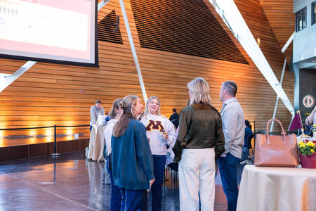 Attendees stand and talk at the Alumni Weekend reception 
