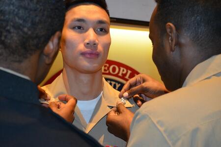 Quang Tran receives a pin on his lapel