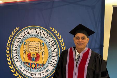 Petker poses with the American College of Dentists logo