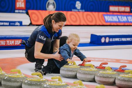 Peterson and her son play with Curling rocks 