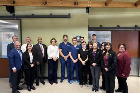 A group of students and faculty pose with Rebecca Cunningham and Dean Mays