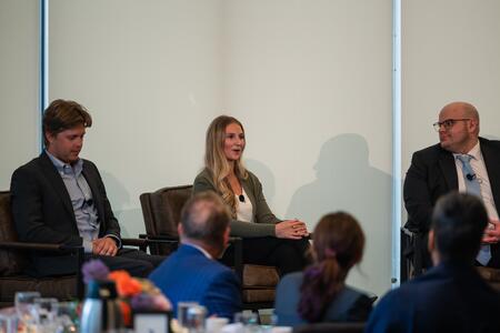 Bridget Ahern speaks onstage between Charlie Brimacombe and Alex Petronio