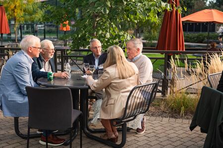 Alumni chat outside McNamara Hall during a reception