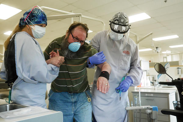 Dentists help a patient to the care area