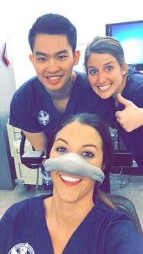 Peterson and classmates smile at the camera while practicing with nitrous oxide
