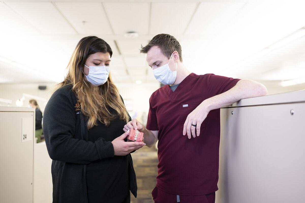 Orthodontics residents examine model teeth in the orthodontics clinic