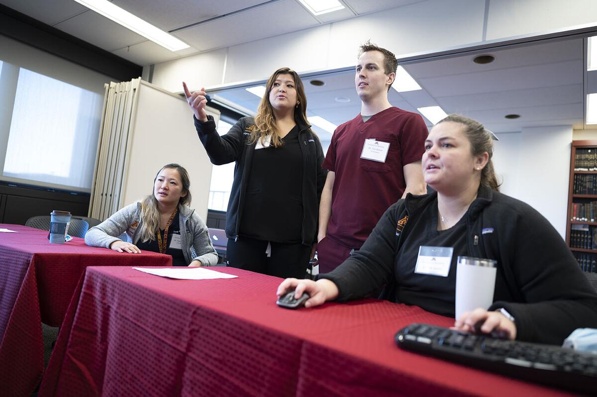 A group of orthodontics residents discuss a case in a conference room