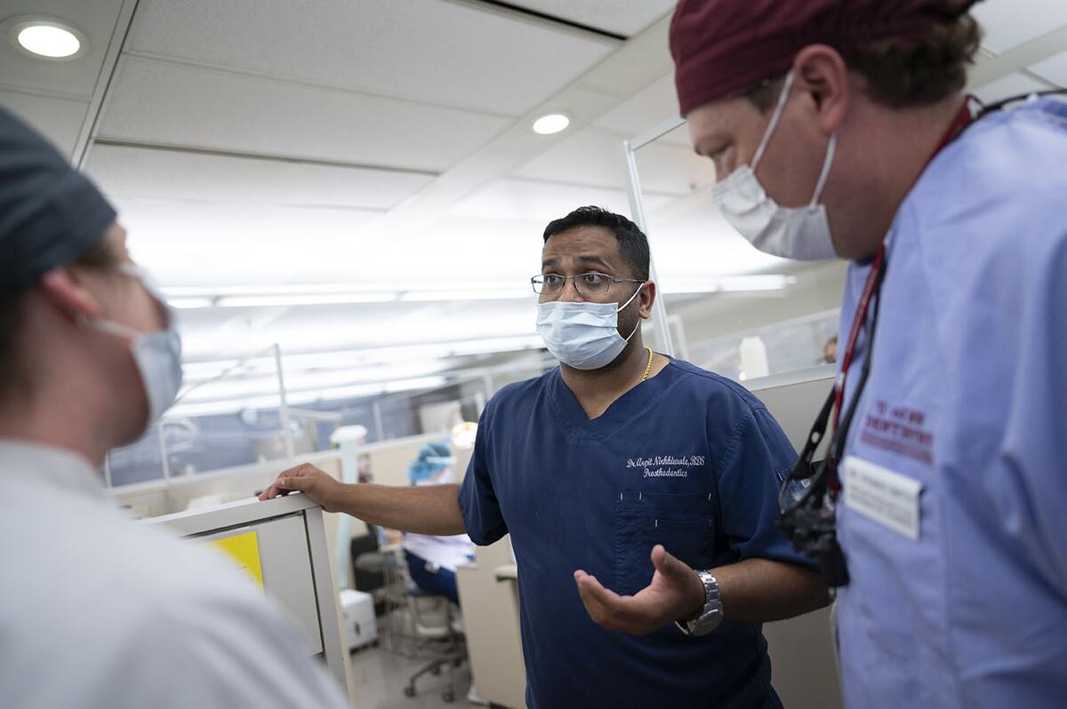 Prosthodontics faculty discuss a patient in the clinic
