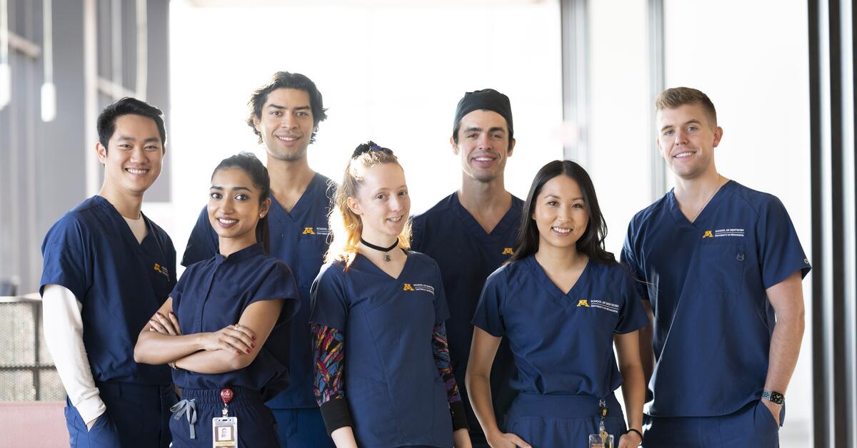 group of DDS students in a group photo shoot smiling for the camera