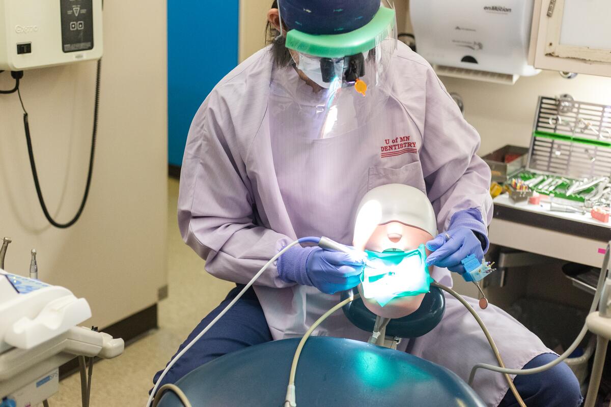 a DDS student works on a plastic model while training on surgury