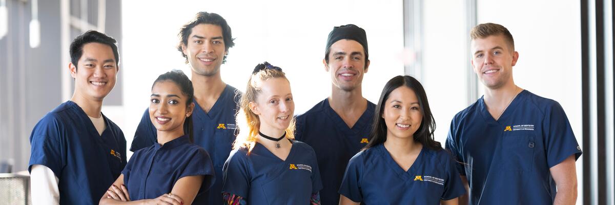 group of DDS students in a group photo shoot smiling for the camera