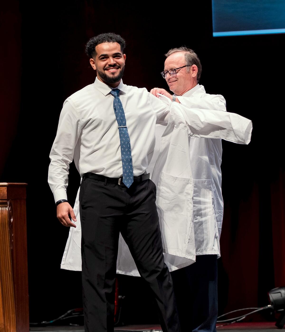 student receives white coat during 2023 White Coat Ceremony