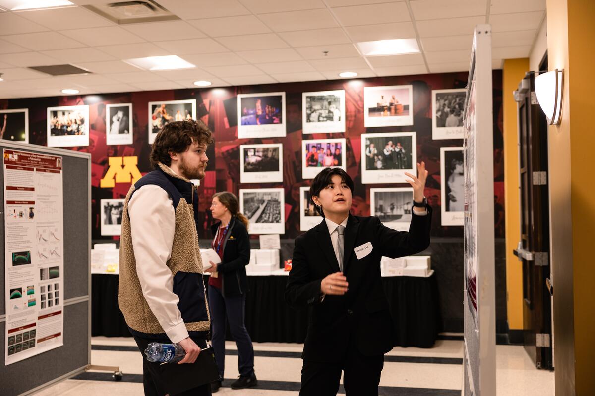 Researchers share their posters with attendees