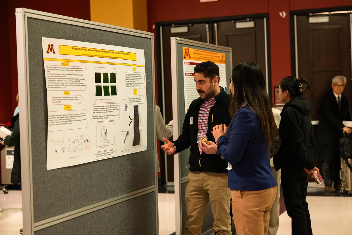 Researchers share their posters with attendees