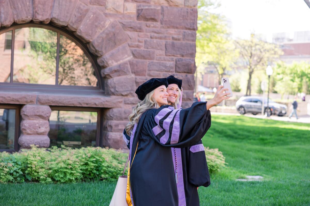 Graduates take a selfie outside 