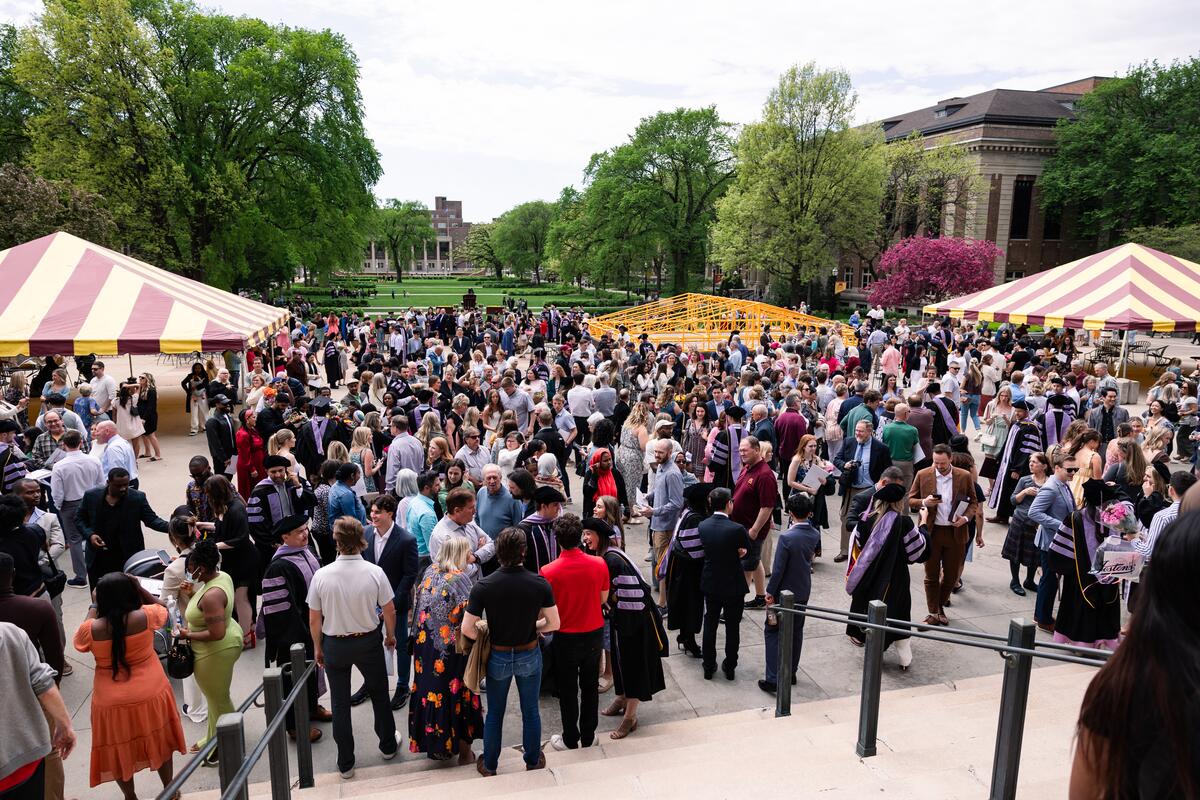Wide shot of guests and graduates outside Northrop