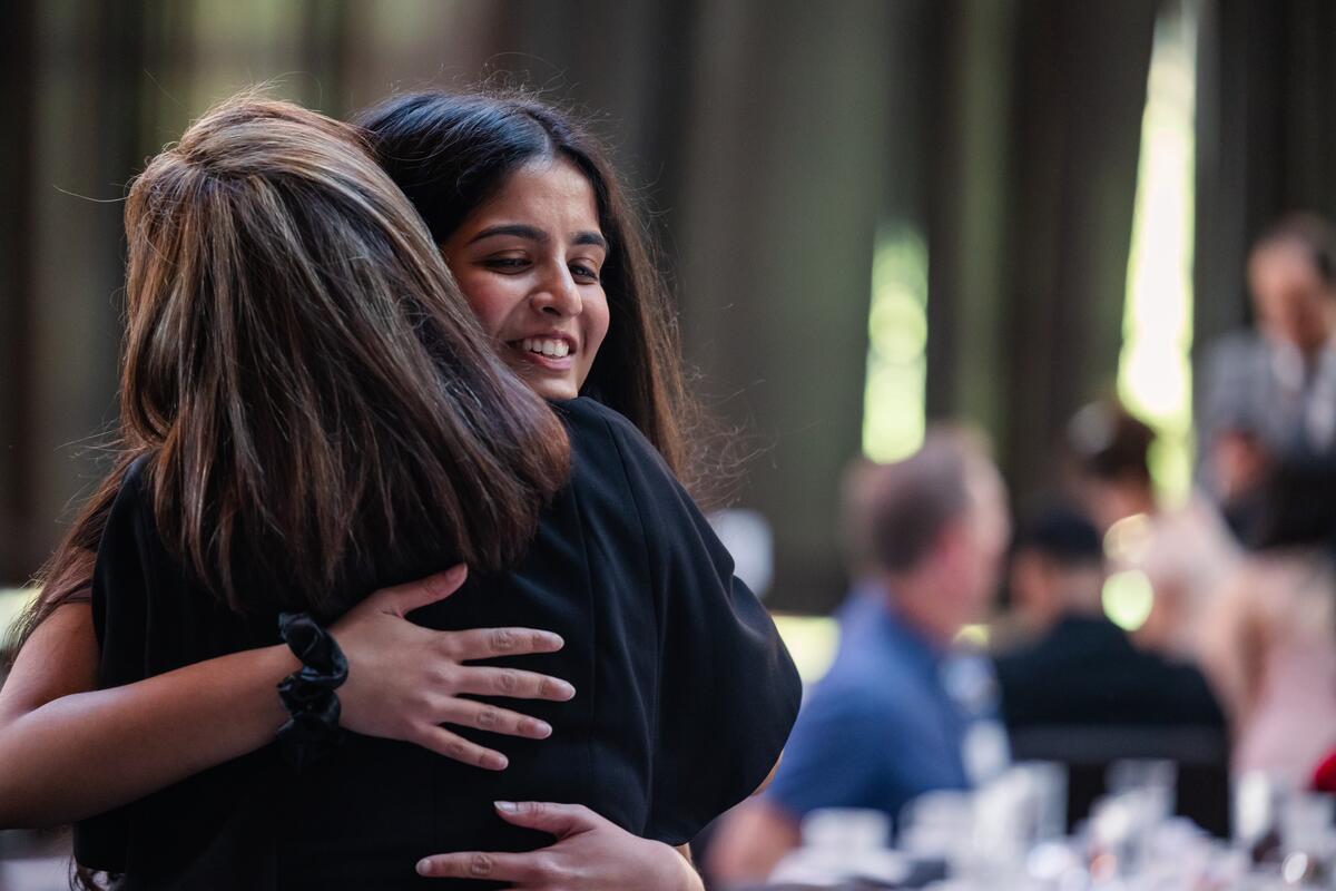 A student and guest embrace