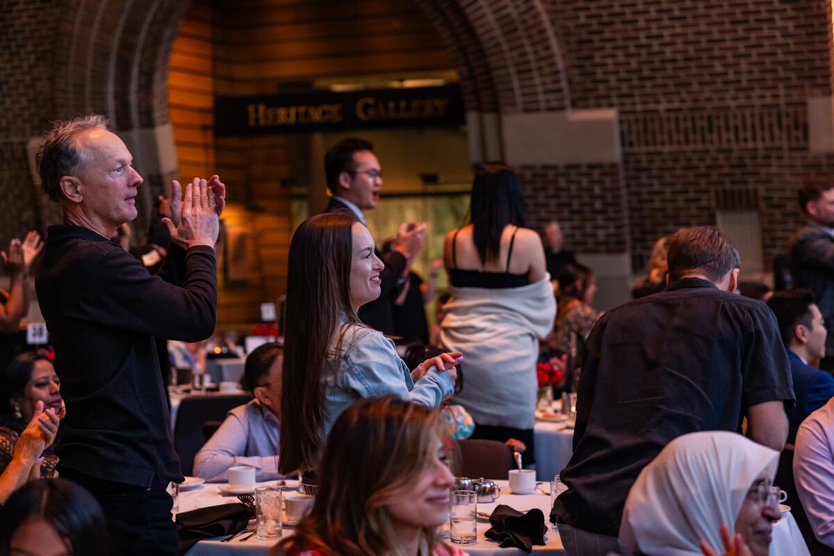Attendees stand and applaud