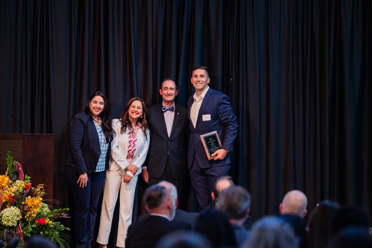 Student and presenters pose with award onstage