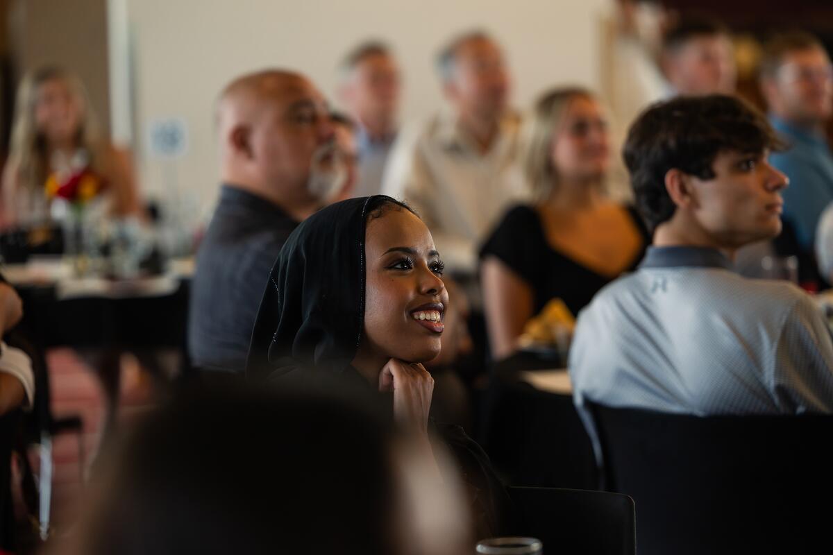 Lubna Abdirahman smiles as she watches a presentation 