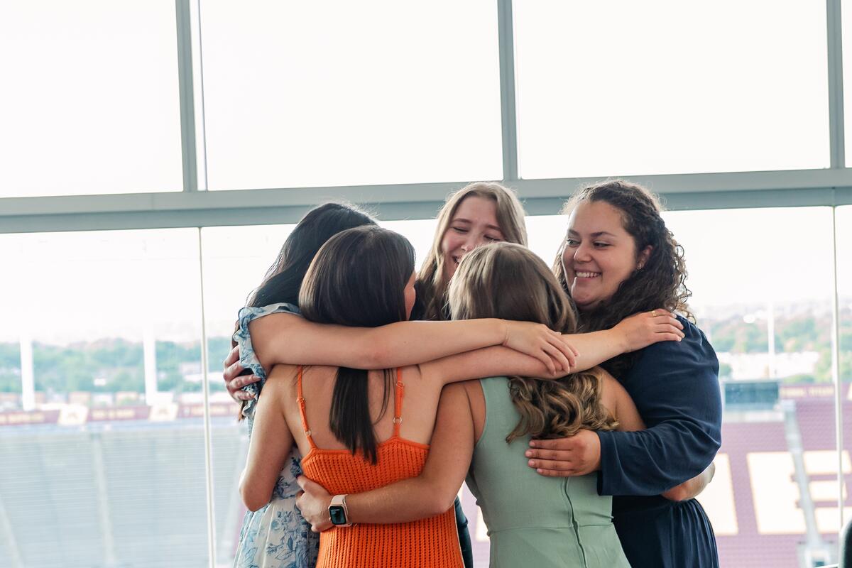 Graduates smile and hug