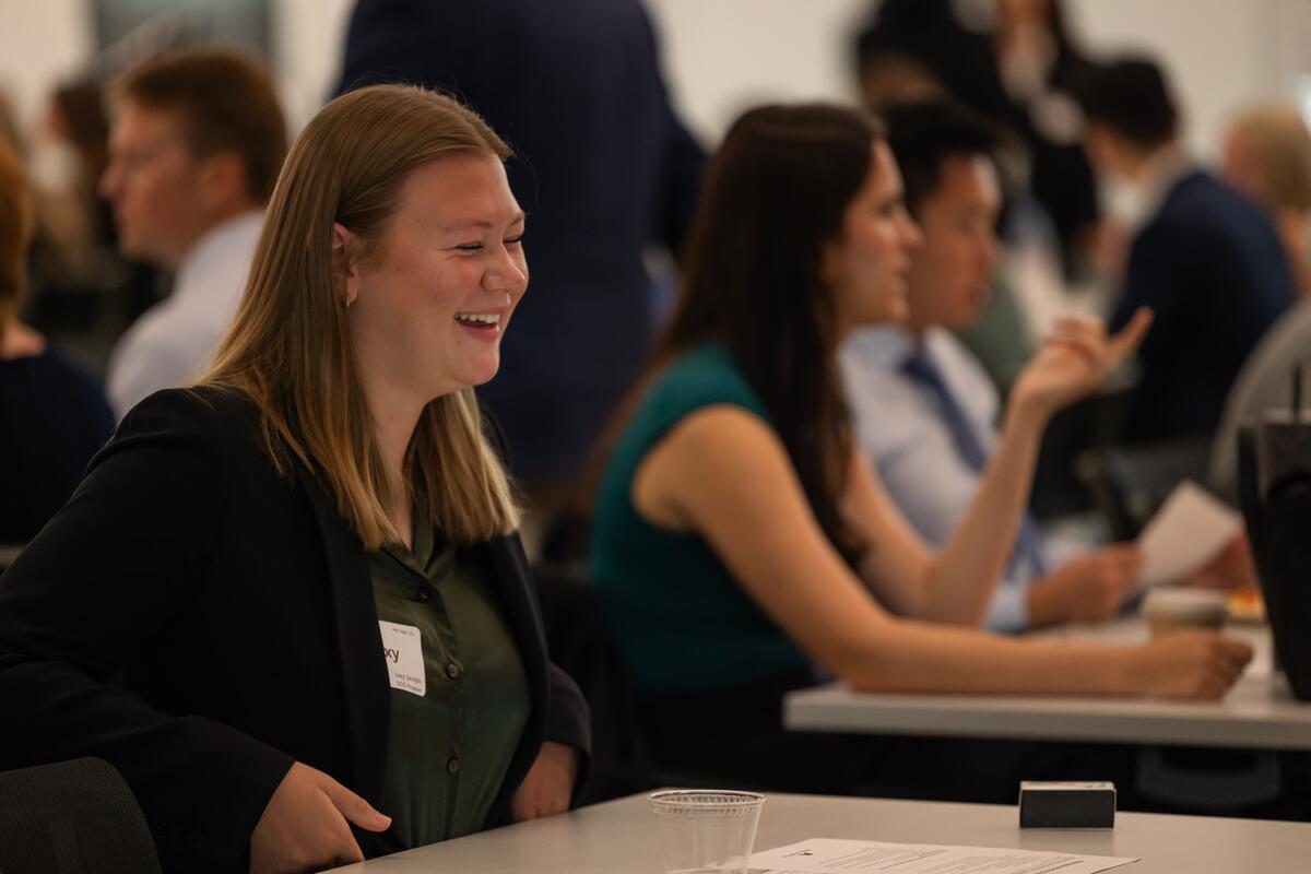A student smiles and talks with her seatmate at orientation