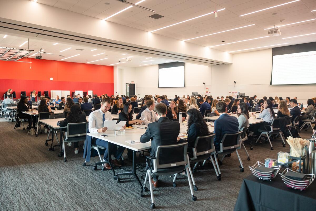 Wide shot of incoming students enjoying breakfast and chatting at orientation
