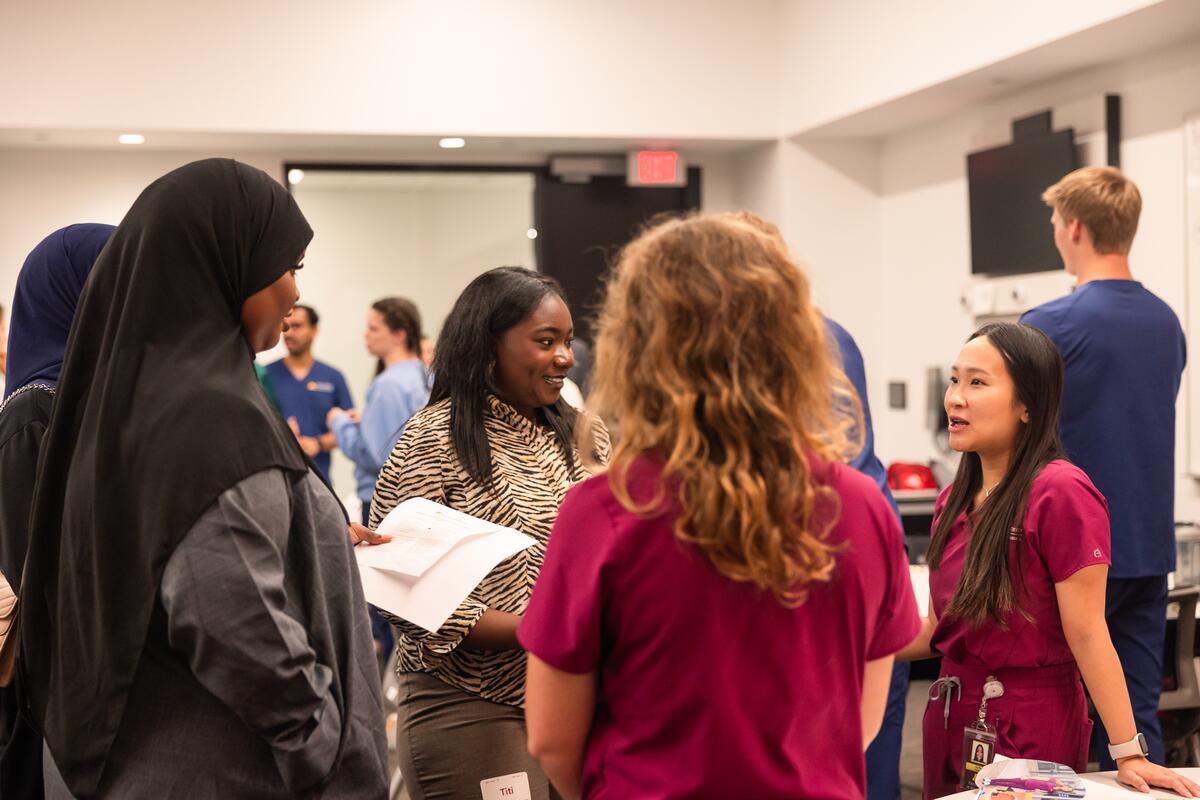 Student talks with current dental hygiene students at the involvement fair